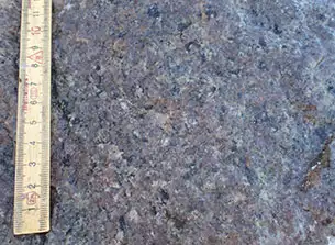 Tøveldestenen består af mellemkornet homogen granit