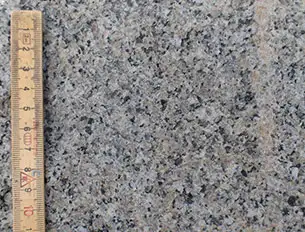 Stenen er mellemkornet og homogen med granittens tre mineraler: Blegt rød kalifeldspat, hvid plagioklas og glasagtigt kvarts